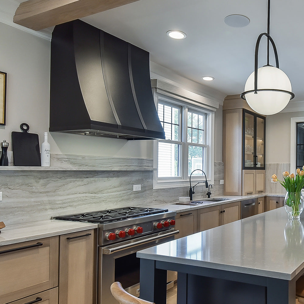 black enamel range hood installed in a kitchen with custom cabinets