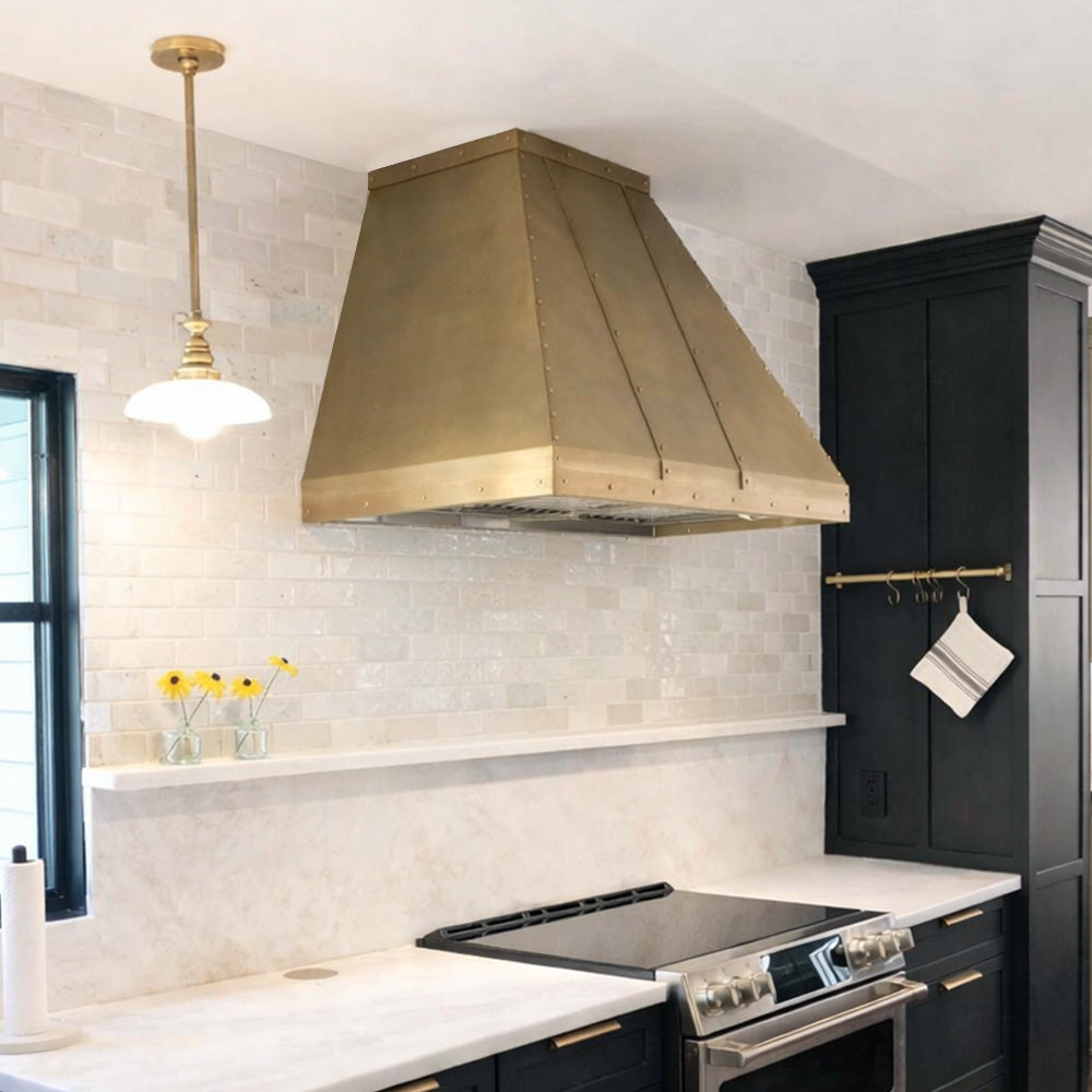 antique brass range hood installed in a modern kitchen
