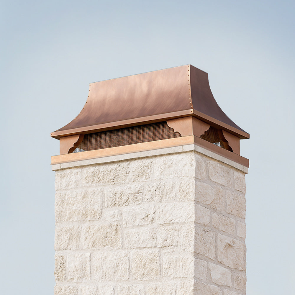 Stone chimney with a copper roof against a clear blue sky