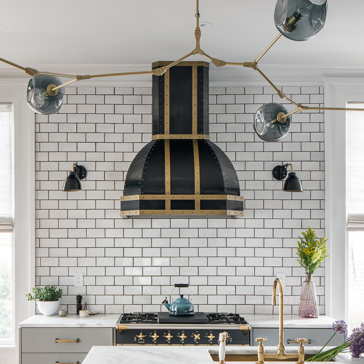 custom white kitchen with black range hood and brass accents