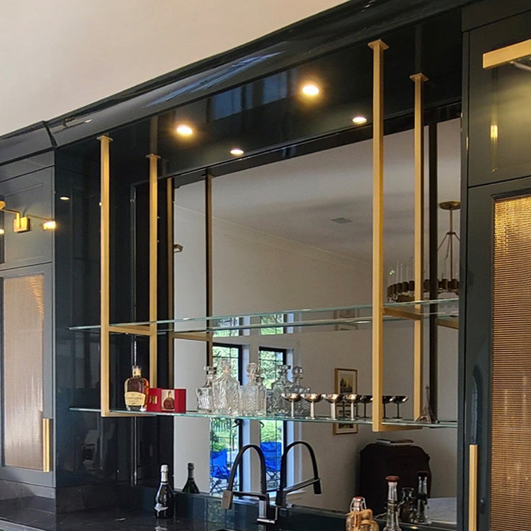 custom brass bar and glass shelf over a wet bar