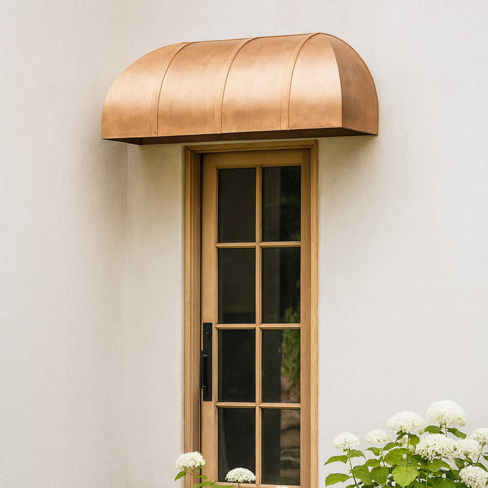 Custom copper door awning with clean architectural lines installed over exterior entry.