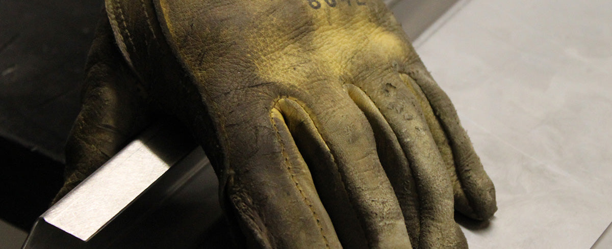 hand of american metalworker holding a piece of premium stainless steel