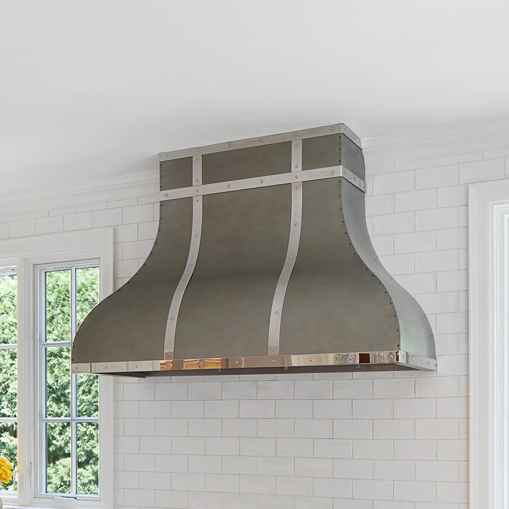 curved zinc vent hood in white transitional kitchen