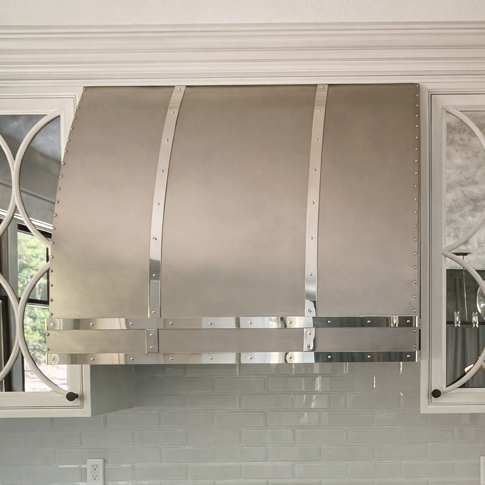 barrel shaped vent hood in stainless with white cabinets