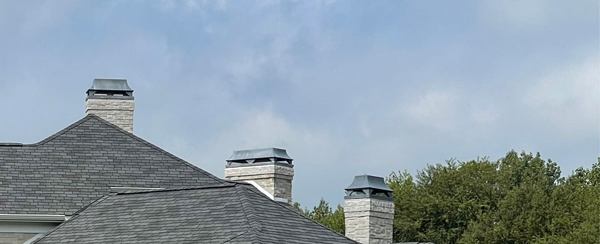three zinc chimney caps on a high end home
