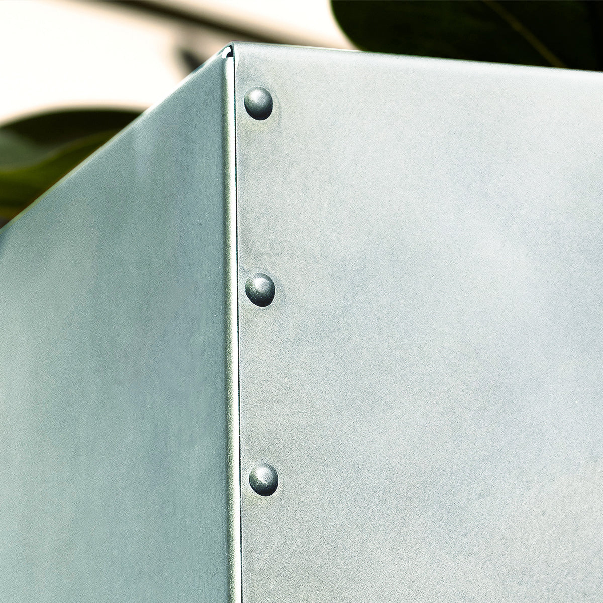 Close-up detail of handcrafted zinc planter showing natural metal texture.